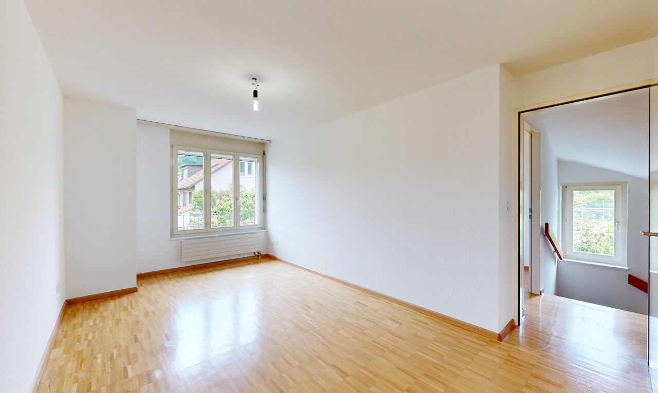 empty room featuring light wood finished floors, radiator heating unit, and plenty of natural light