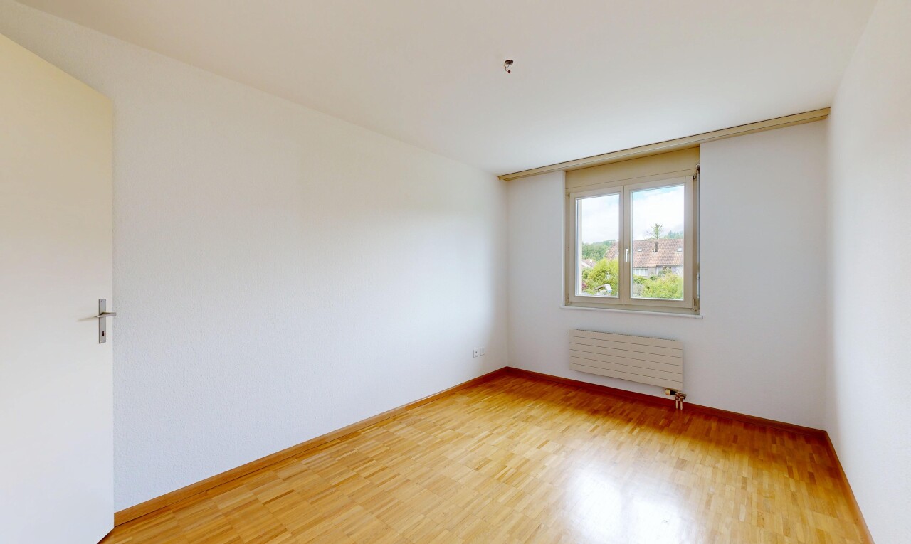 empty room with light wood-type flooring and radiator heating unit
