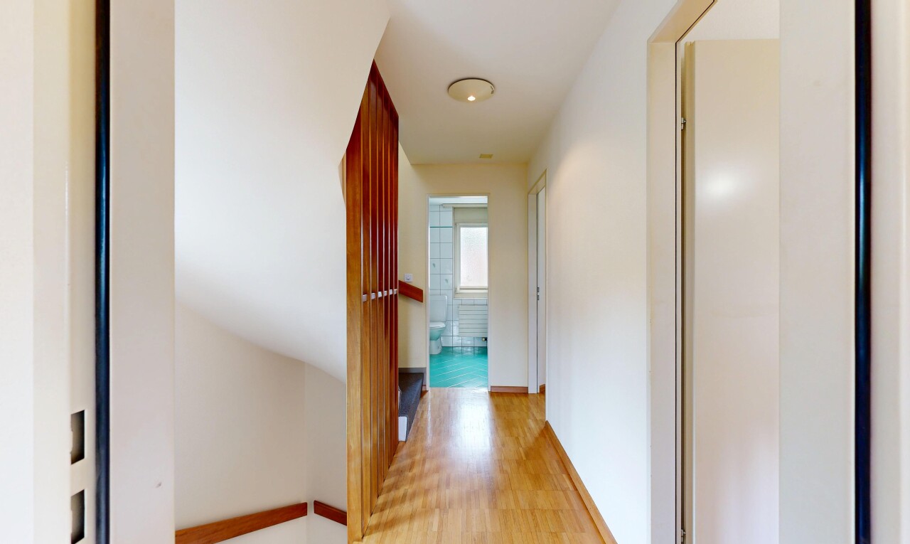 hallway with light wood-style flooring and baseboards