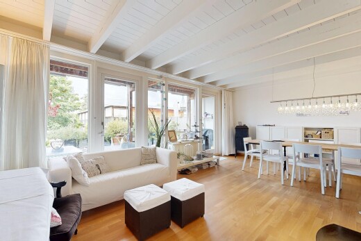 wohn- / esszimmer mit beamed ceiling, balkendecke, high end ceiling, wood finish floor, und holzfußboden