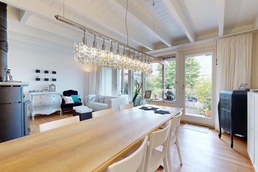 wohn- / esszimmer mit beamed ceiling, balkendecke, high end ceiling, wood finish floor, und holzfußboden