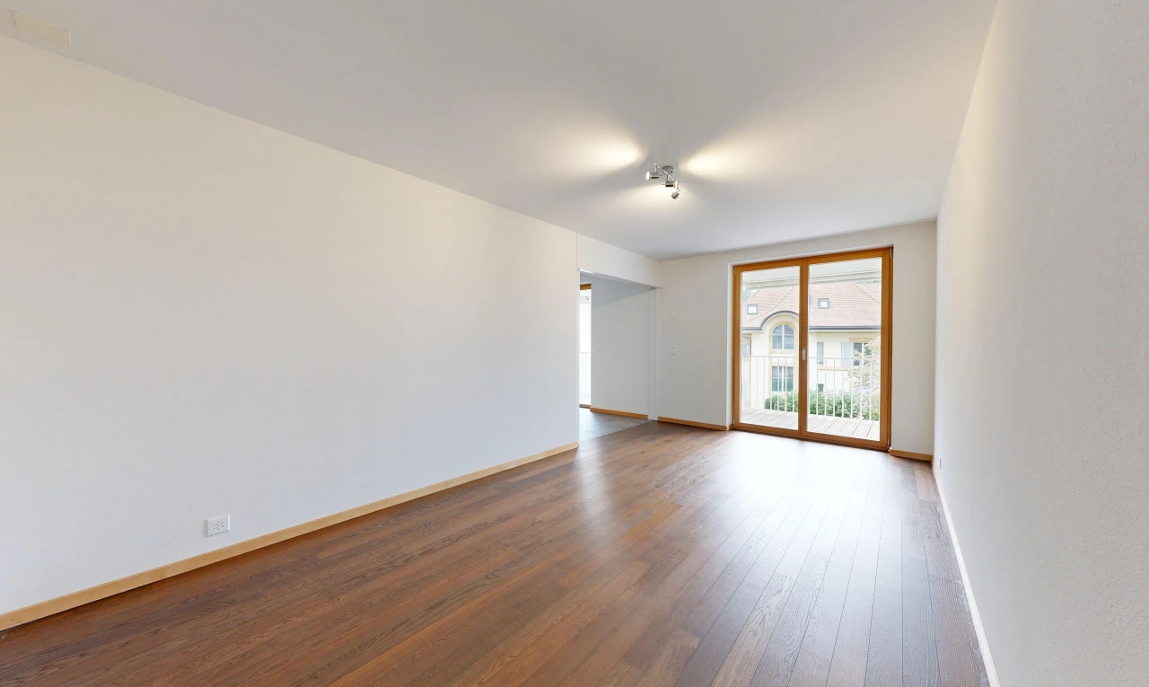pièce vide avec cloison sèche, drywall, accès à l'extérieur, sol en finition bois, et wood finish floor