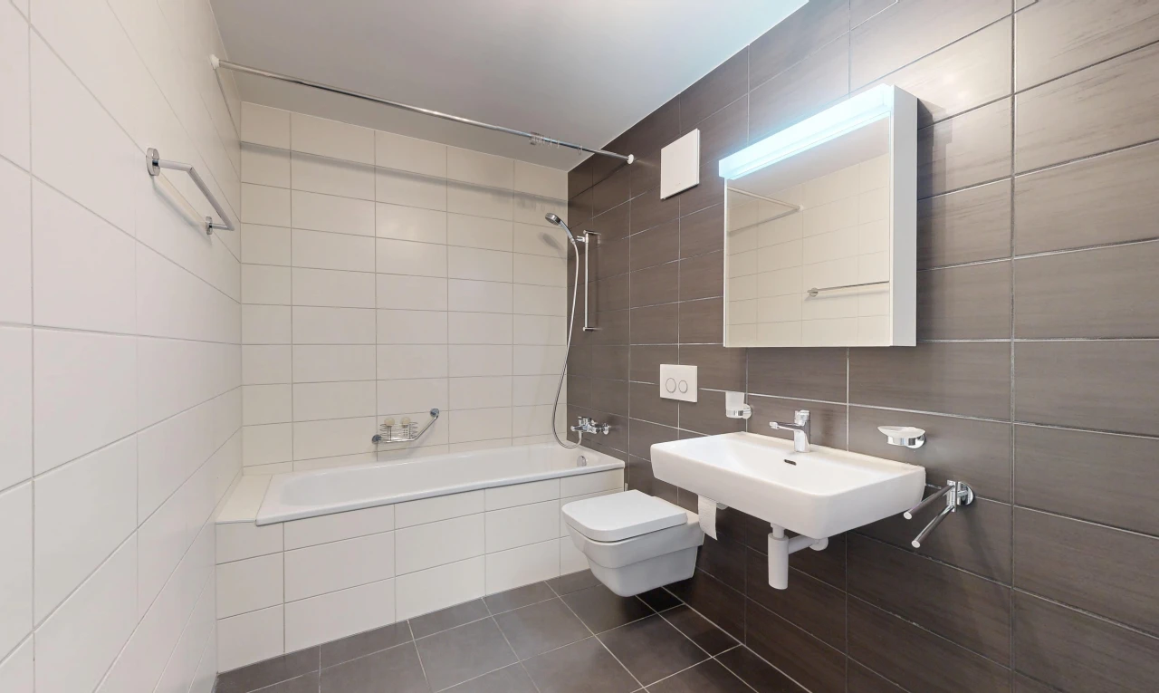 salle de bains avec douche-bain combinés, tile wall, mur en carrelage, miroir, et salle de bain complète