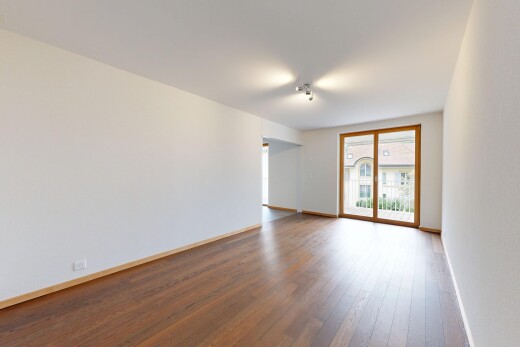 pièce vide avec cloison sèche, drywall, accès à l'extérieur, sol en finition bois, et wood finish floor