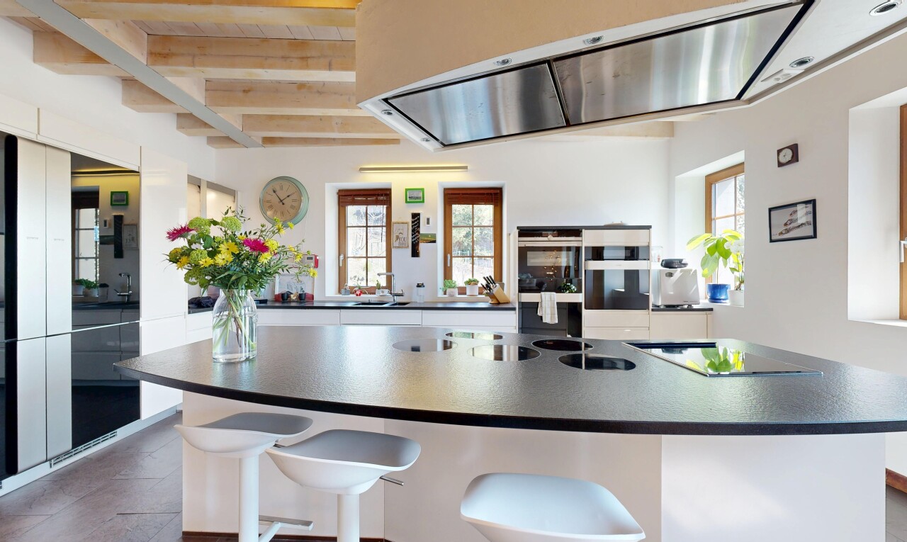 kitchen with double wall oven, dark countertops, range hood, and plenty of natural light