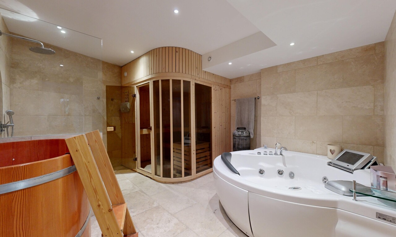 bathroom featuring a jetted tub, tile walls, and recessed lighting