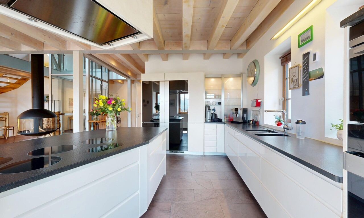 kitchen with white cabinetry, wooden ceiling, a sink, dark countertops, and beam ceiling