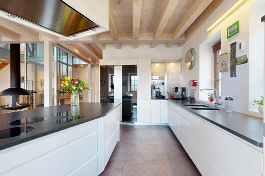 kitchen with white cabinetry, wooden ceiling, a sink, dark countertops, and beam ceiling