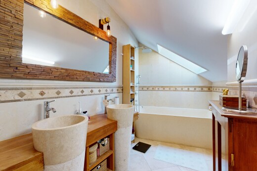 salle de bains avec puits de lumière, mur en carrelage, salle de bain complète, plafond voûté, et bain