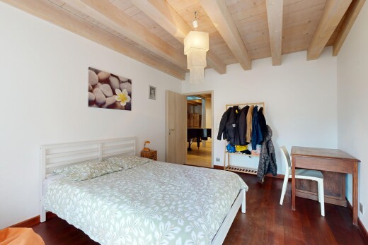 chambre avec plafond en bois, plafond à poutres, cloison sèche, et sol en finition bois