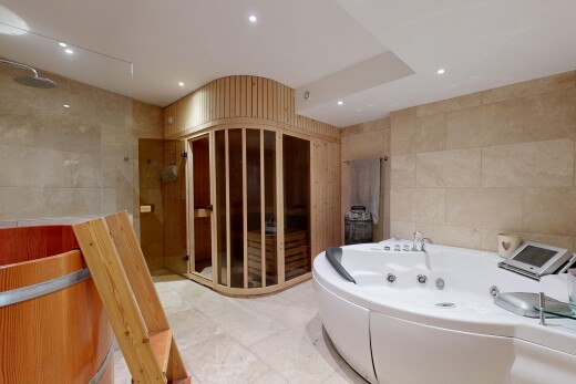 salle de bains avec bain, éclairage encastré, salle de bain complète, et mur en carrelage