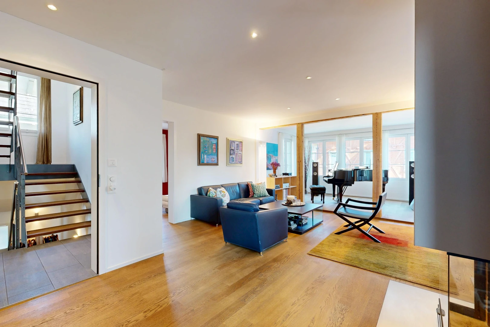 wohnzimmer mit treppen, einbauleuchten, drywall, gipskartonwand, und wood finish floor