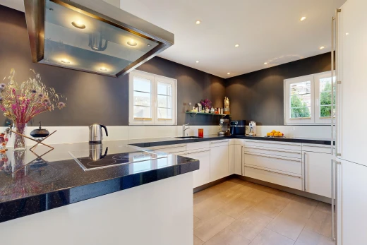 küche mit dunstabzugshaube, dark countertops, arbeitsplatten, einbauleuchten, und light floor