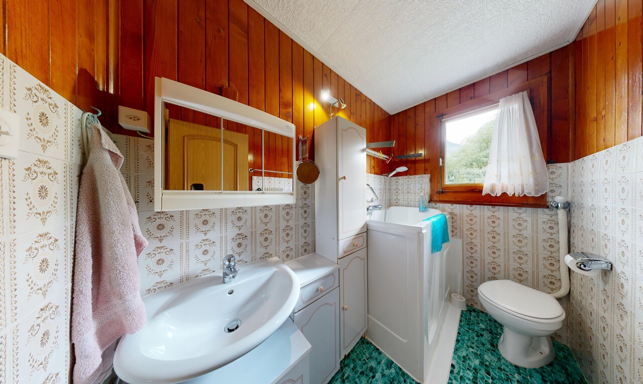 bad mit waschbecken, spiegel, spritzputz decke, textured ceiling, und toilette