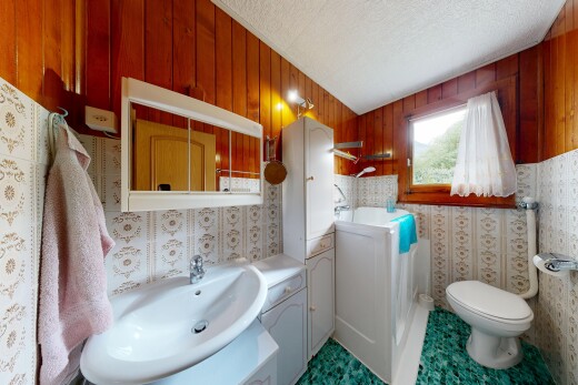 bad mit waschbecken, spiegel, spritzputz decke, textured ceiling, und toilette