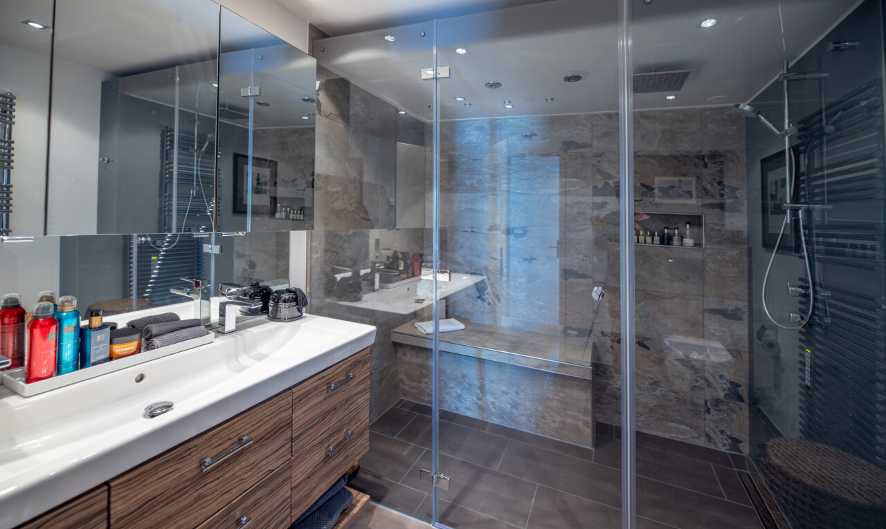 salle de bains avec lavabo (ou coiffeuse selon le contexte), salle de bain complète, douche, inside property, et dark floor