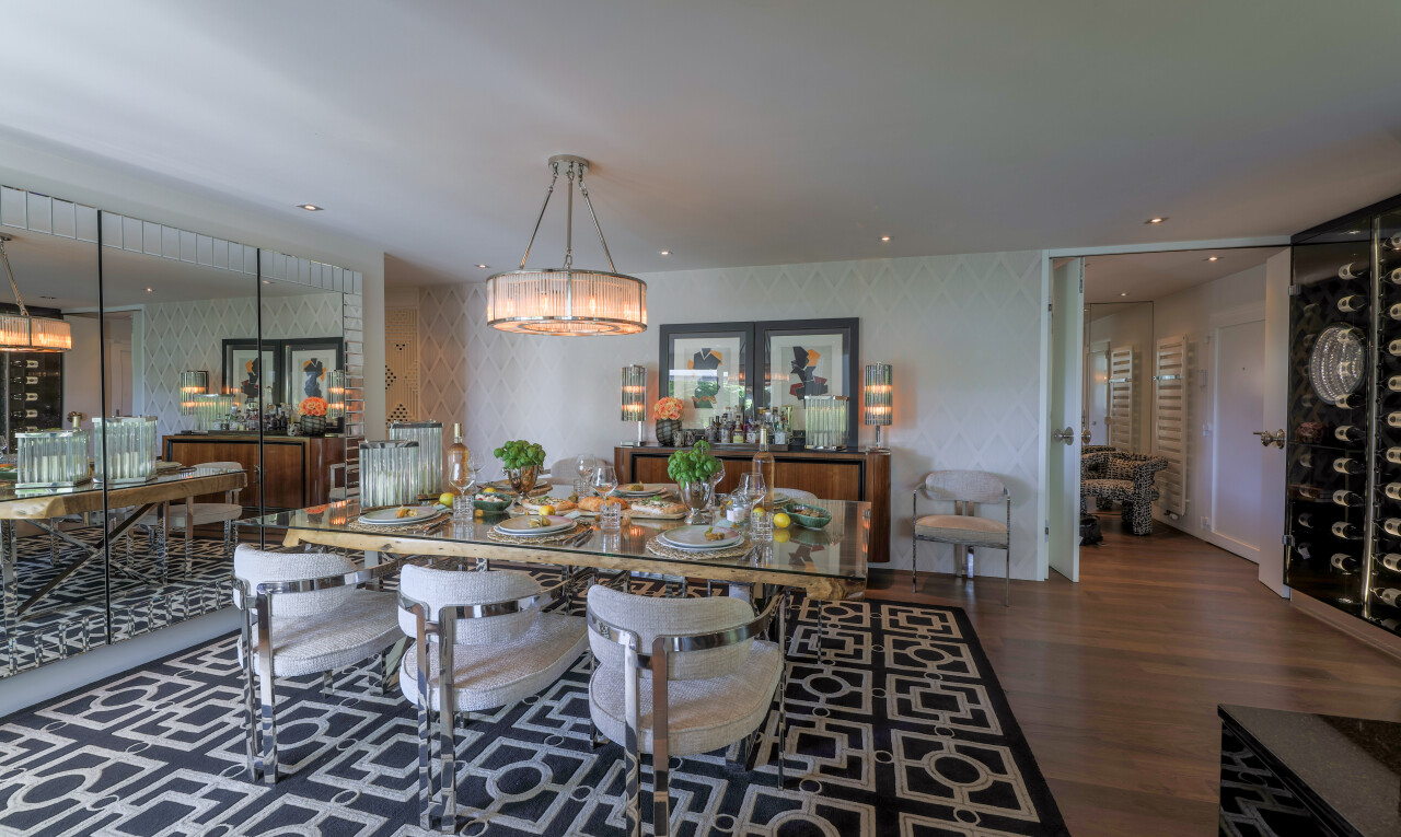 salle à manger avec inside property, wood finish floor, sol en finition bois, lustre remarquable, et dark floor