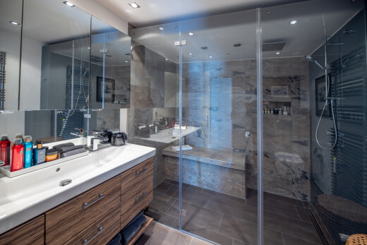 salle de bains avec lavabo (ou coiffeuse selon le contexte), salle de bain complète, douche, inside property, et dark floor