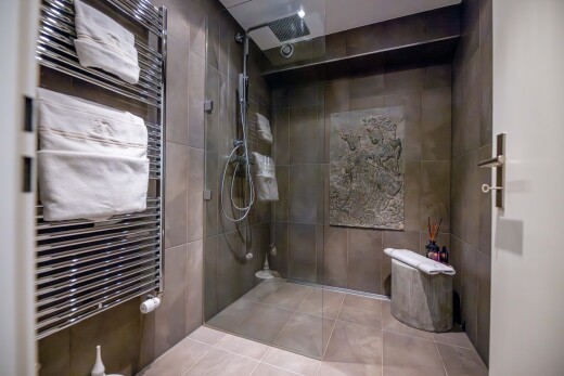salle de bains avec radiateur, chauffe-serviettes, douche, salle de bain complète, et inside property