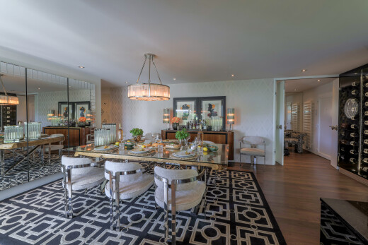 salle à manger avec inside property, wood finish floor, sol en finition bois, lustre remarquable, et dark floor
