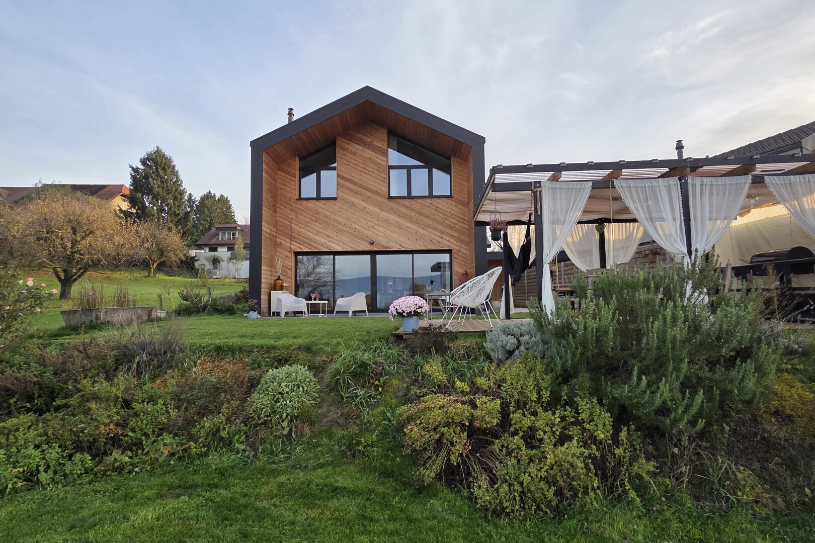 außenansicht mit holzverkleidung, terrasse, property visible, horizontale verkleidung, und rasen