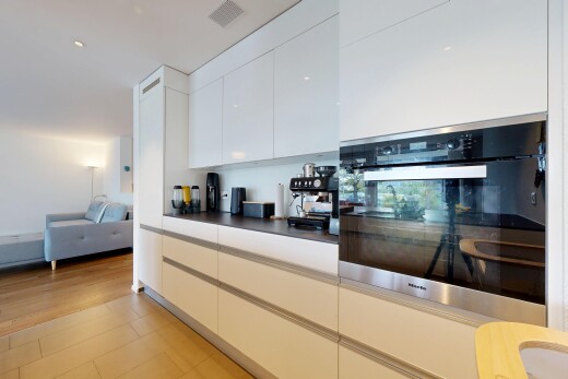 cuisine avec four, dark countertops, plans de travail, flat panel cabinets, et armoires à panneau plat