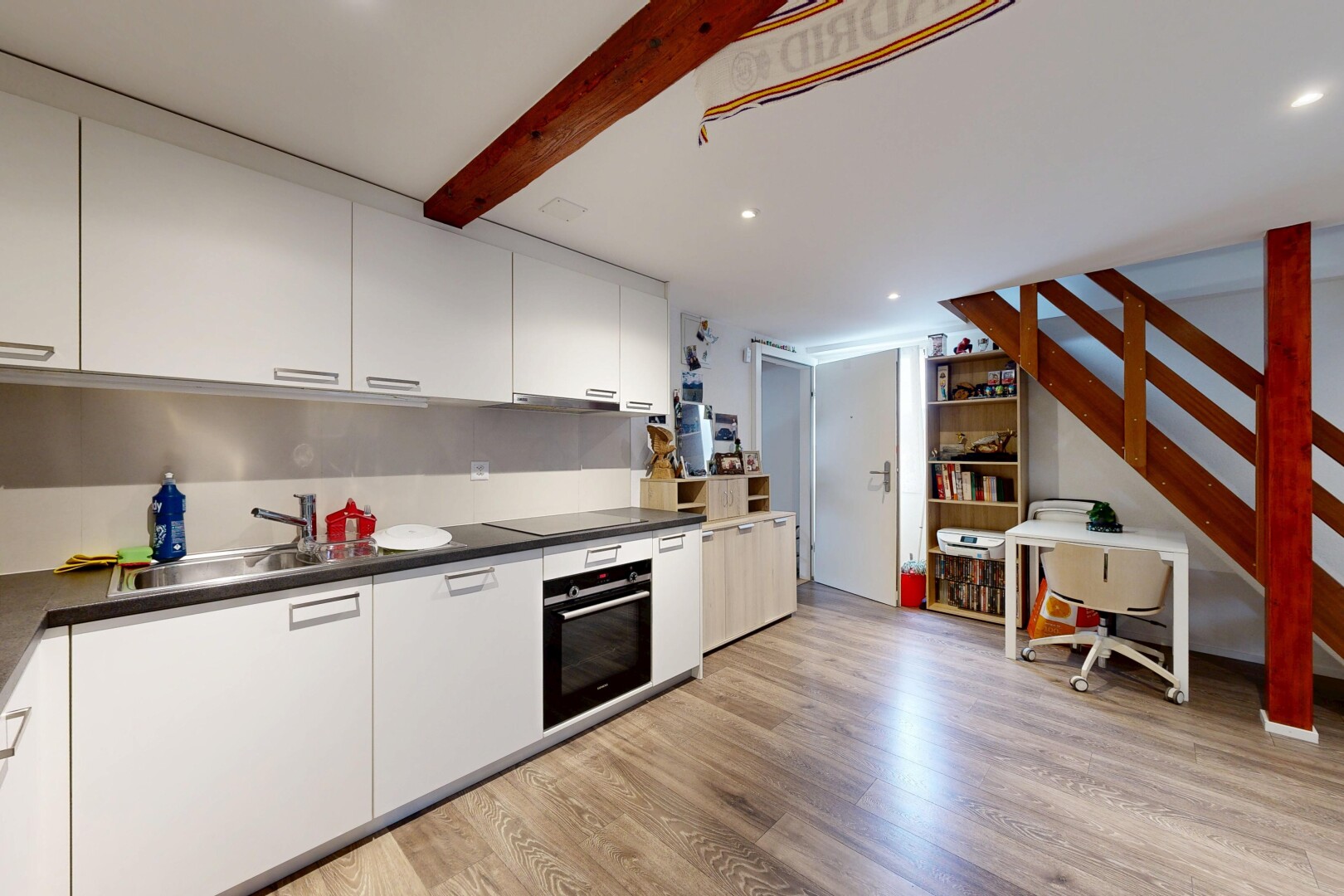 cuisine avec sol en finition bois, wood finish floor, plans de travail, armoires blanches, et four