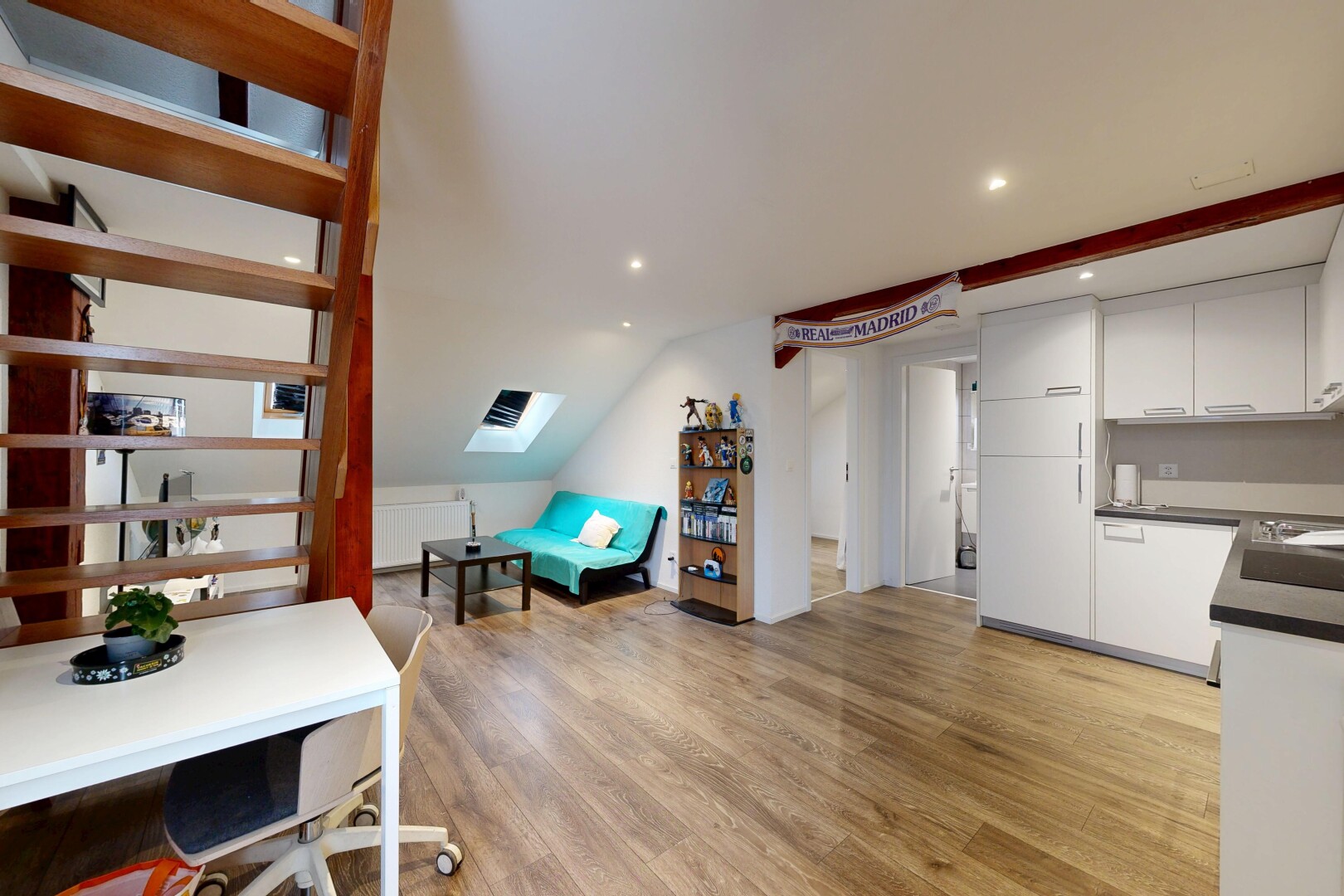 cuisine avec armoires blanches, plans de travail, inside property, sol en finition bois, et wood finish floor