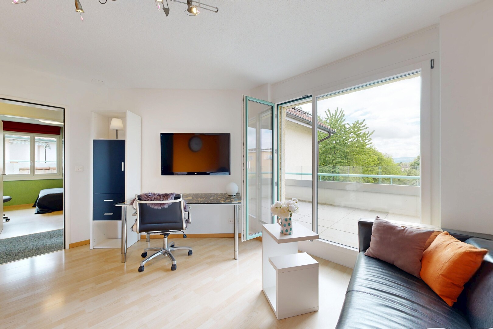 wohnzimmer mit fernseher, gipskartonwand, drywall, holzfußboden, und wood finish floor