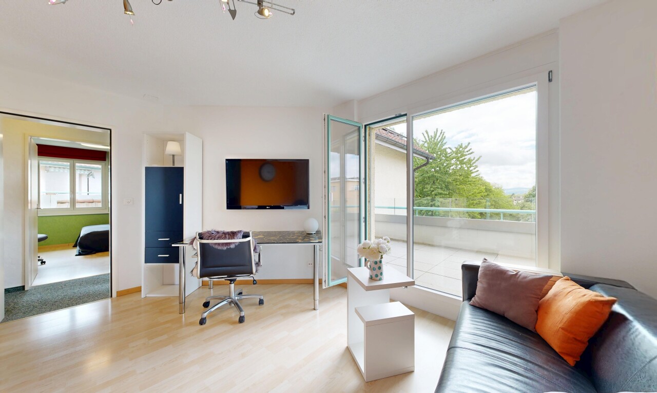 wohnzimmer mit fernseher, gipskartonwand, drywall, holzfußboden, und wood finish floor