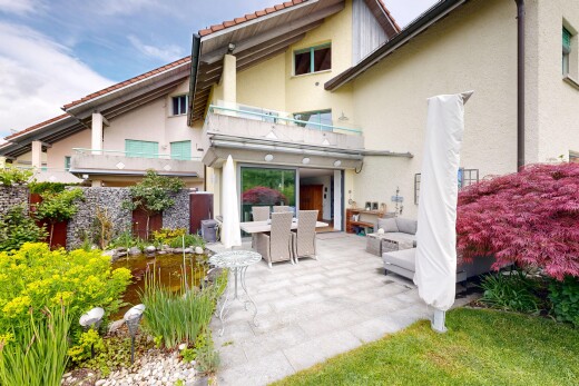 outdoor house featuring an outdoor living / dining area, a balcony, and stucco siding