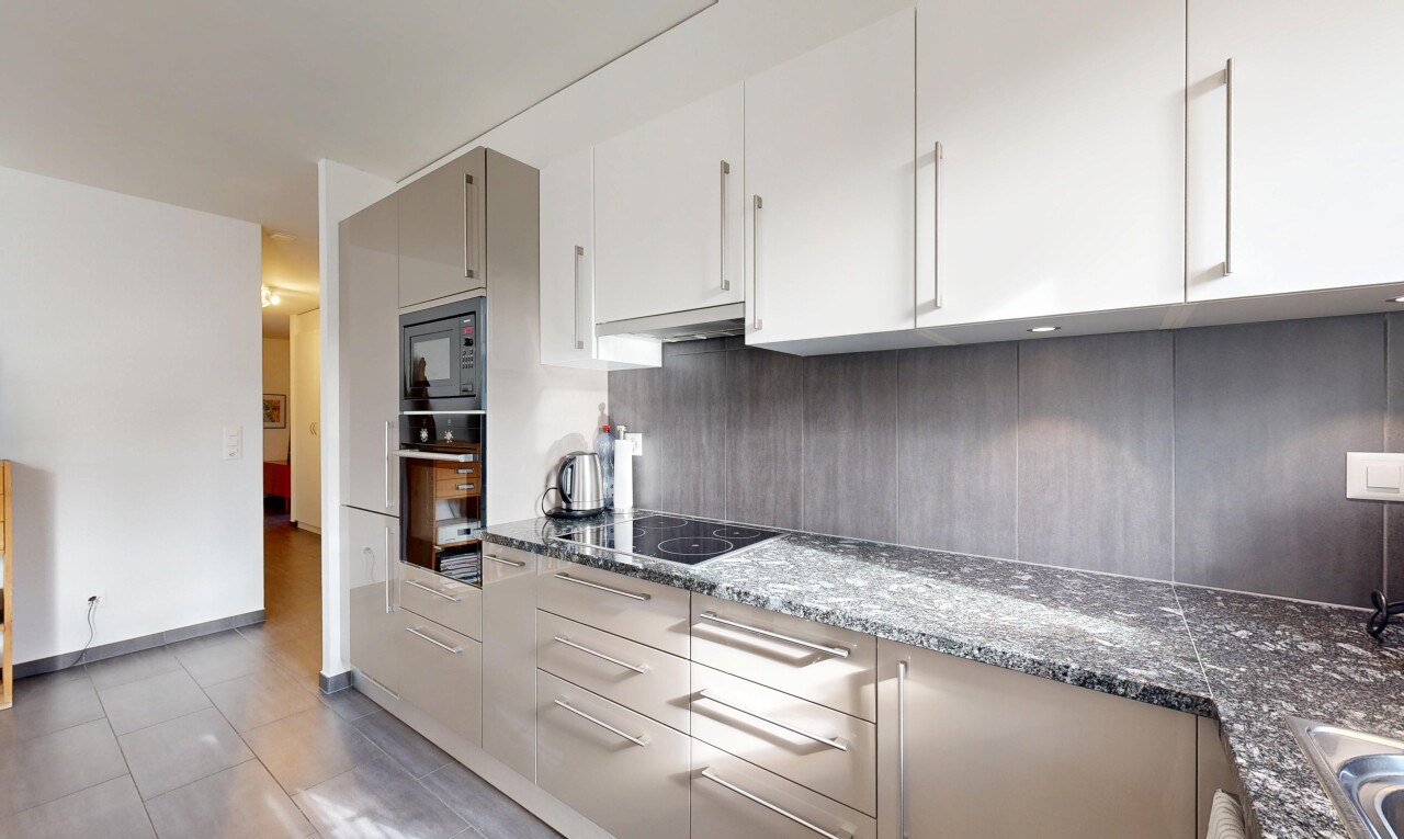 cuisine avec plans de travail en pierre, inside property, four, micro-ondes, et backsplash