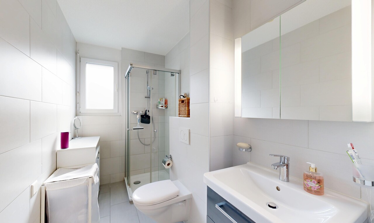 salle de bains avec mur en carrelage, tile wall, lavabo (ou coiffeuse selon le contexte), lumière naturelle, et natural light