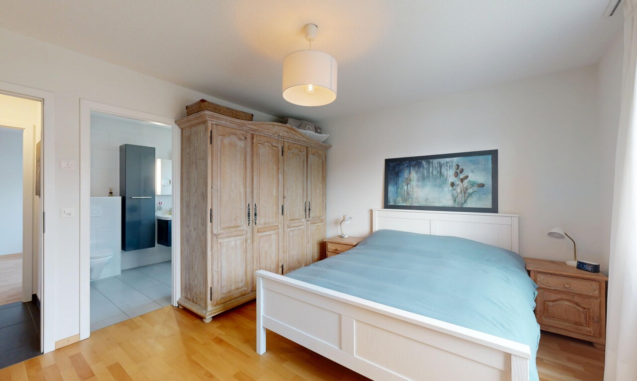 chambre avec wood finish floor, sol en finition bois, drywall, cloison sèche, et placard