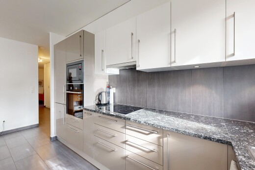 cuisine avec plans de travail en pierre, inside property, four, micro-ondes, et backsplash