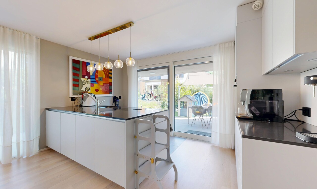 cuisine avec dark countertops, armoires blanches, white cabinets, sol en finition bois, et wood finish floor