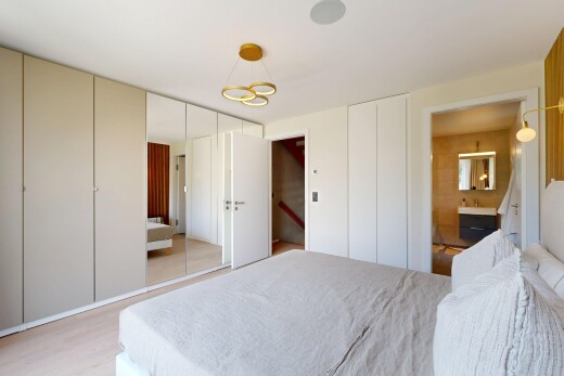 chambre avec placard, sol en finition bois, wood finish floor, inside property, et light floor