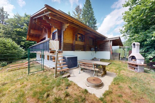 outdoor house featuring a fireplace, a patio area, and a gate
