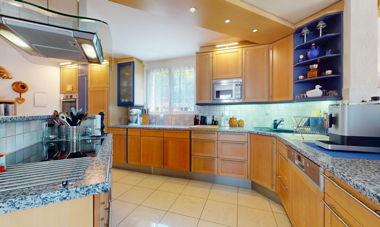 cuisine avec micro-ondes, hotte, dosseret, backsplash, et armoires de style shaker