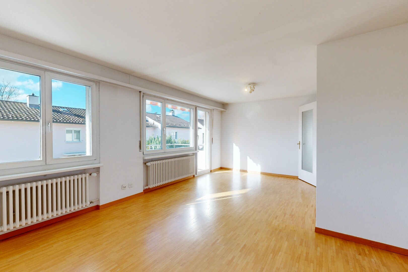 pièce vide avec radiateur, day time, drywall, cloison sèche, et wood finish floor