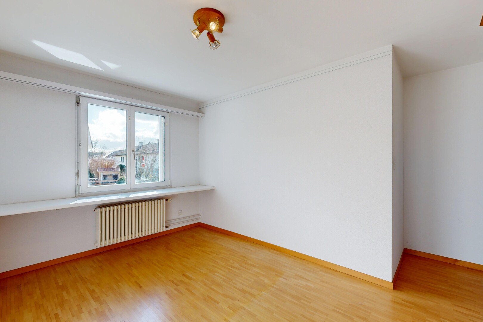 pièce vide avec radiateur, cloison sèche, drywall, sol en finition bois, et wood finish floor