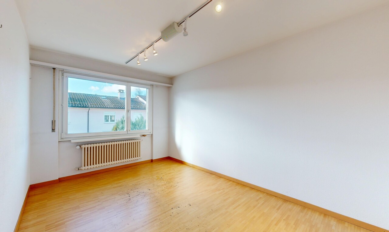 pièce vide avec track lighting, éclairage sur rail, radiateur, wood finish floor, et sol en finition bois