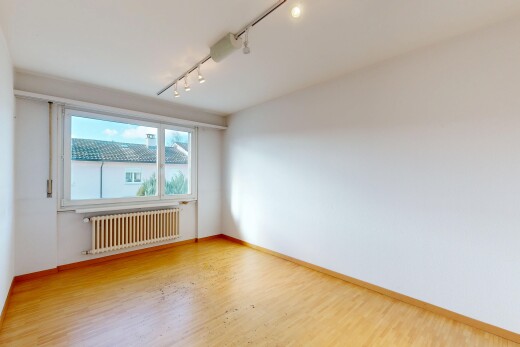 unfurnished room featuring track lighting, radiator, and wood finished floors
