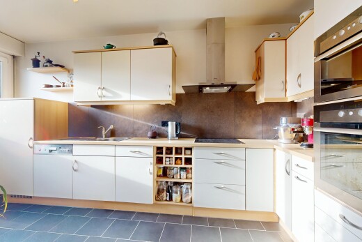 cuisine avec étagères ouvertes, armoires blanches, hotte, dosseret, et backsplash