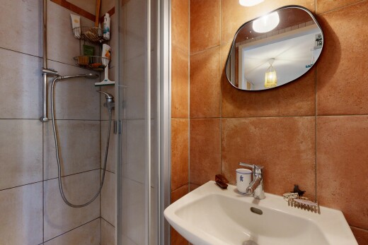 salle de bains avec miroir, douche, salle de bain complète, évier, et inside property