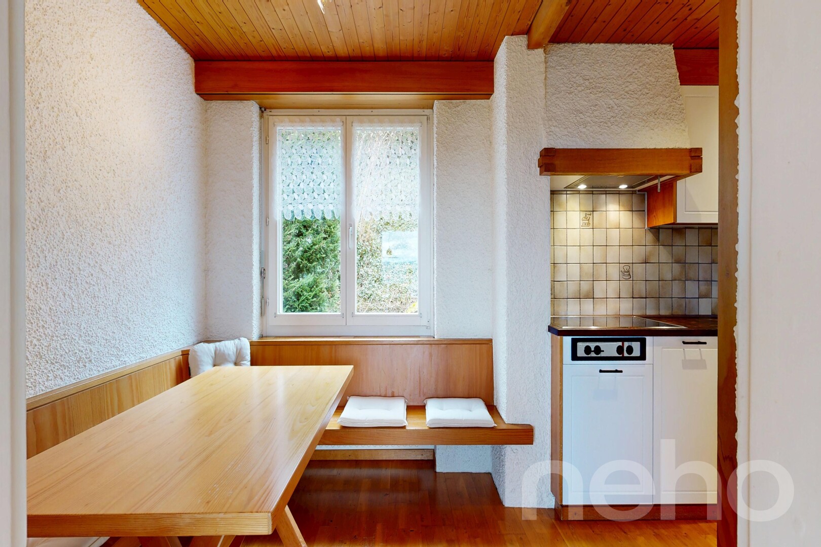 dining room with breakfast area, a wood ceiling with exposed beams, a textured wall, light wood-style floors, and a wainscoted wall
