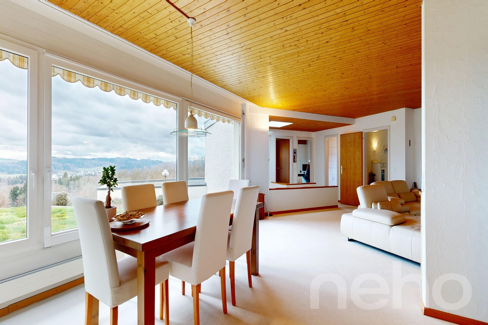 living / dining area with light colored carpet and wood ceiling