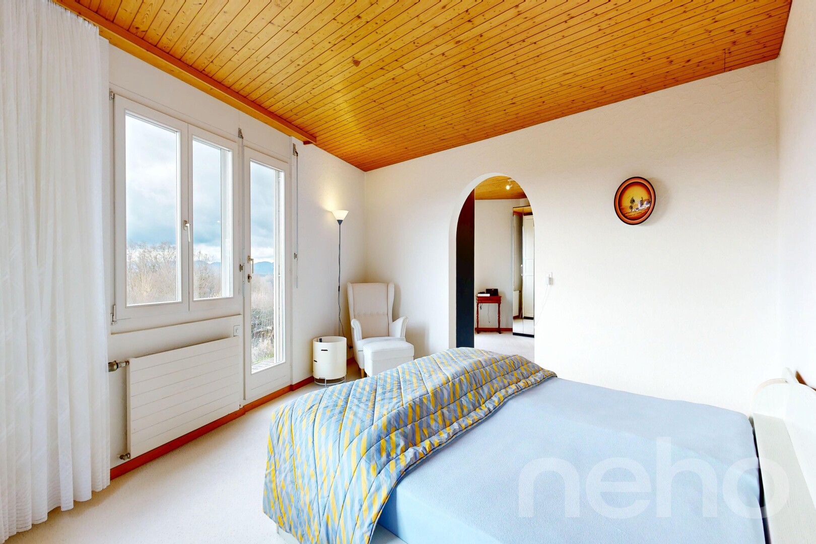 carpeted room featuring arched walkways, radiator heating unit, wooden ceiling, and access to outside