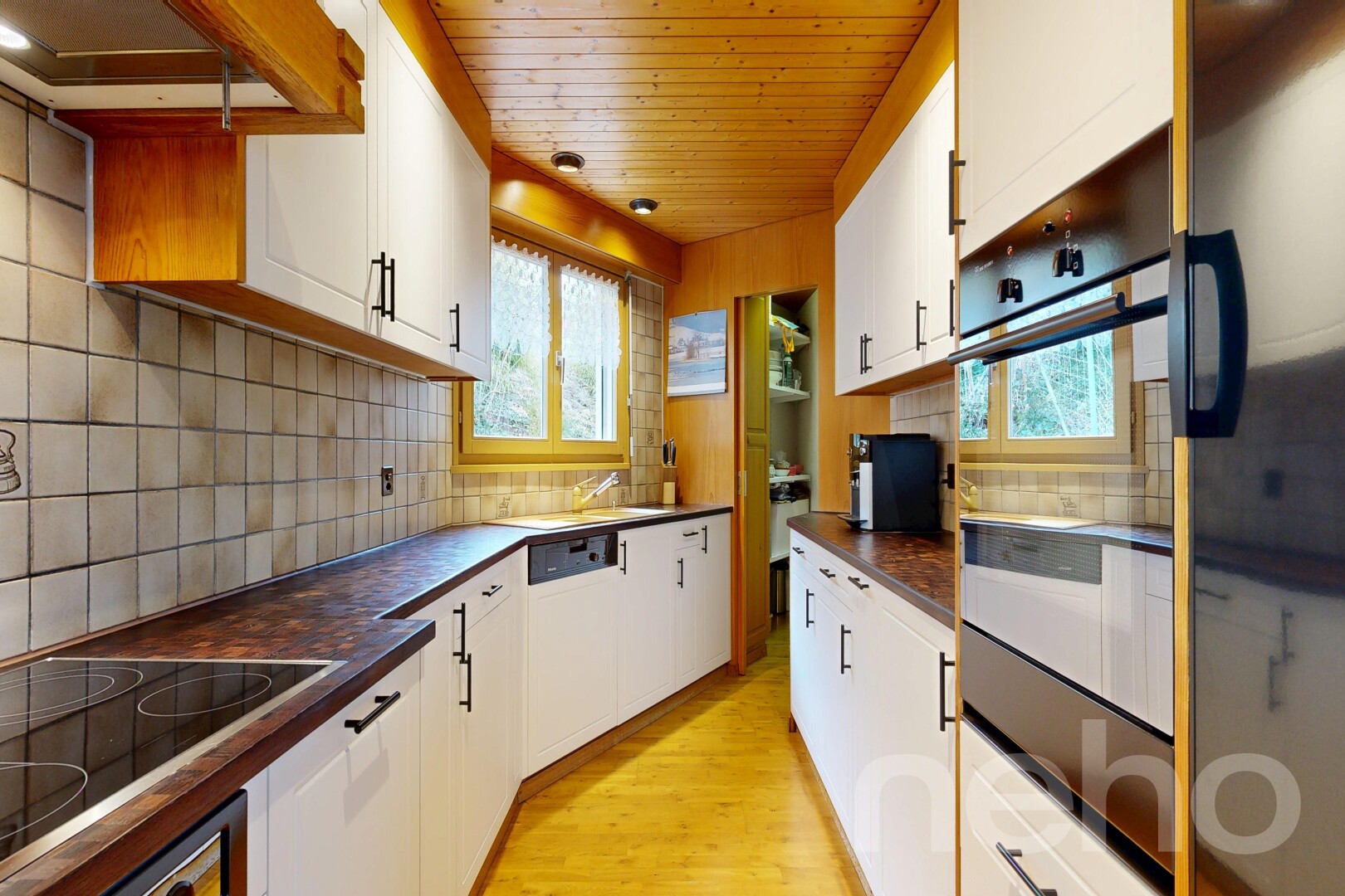 kitchen featuring dark countertops, black appliances, white cabinets, and wooden ceiling
