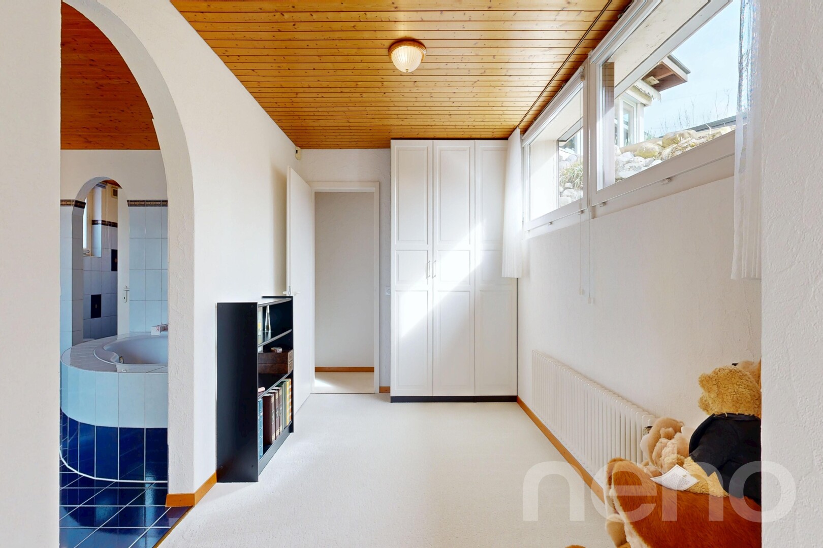 hall featuring arched walkways, wooden ceiling, and light colored carpet